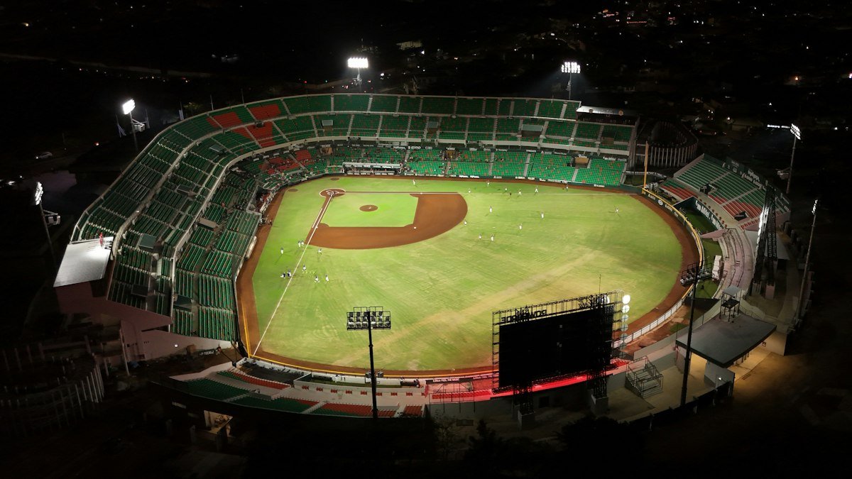 Aerial view of a baseball stadium lit up at night with an empty field